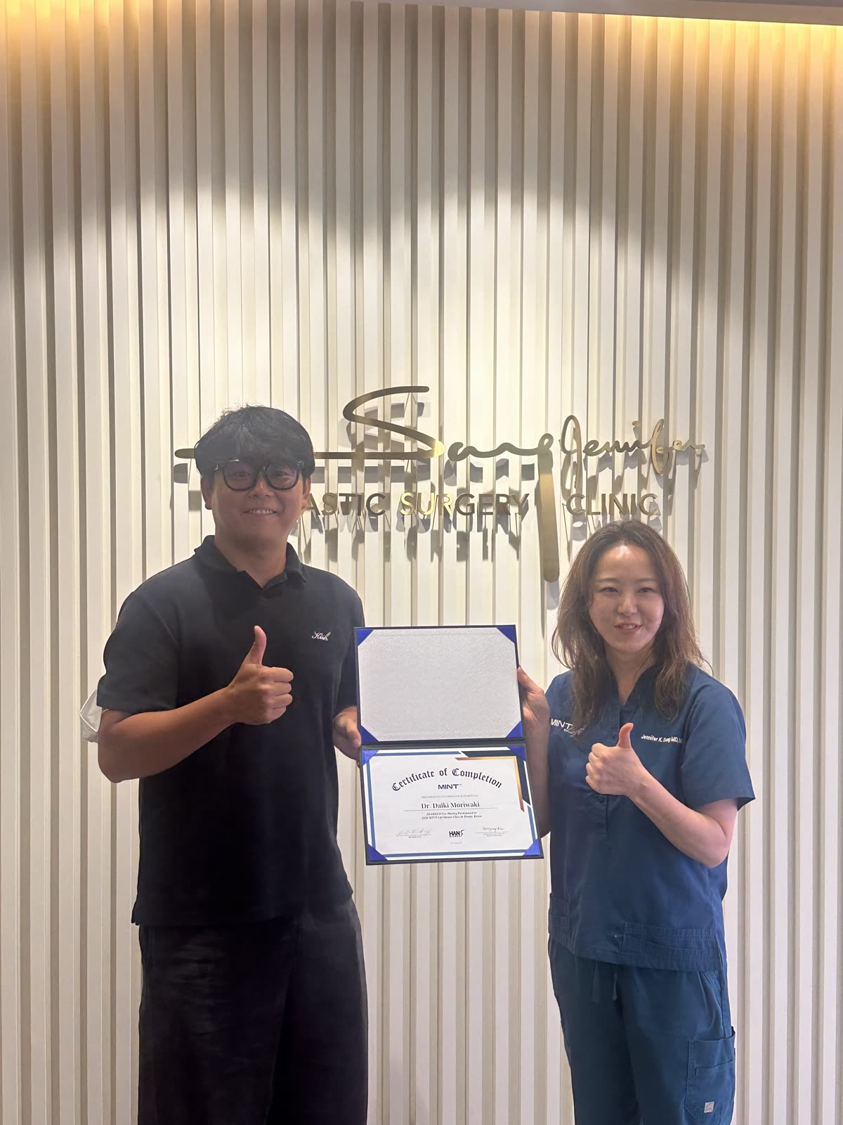 A Japanese physician receiving a MINT Certificate of Completion from Dr. Jennifer K. Song